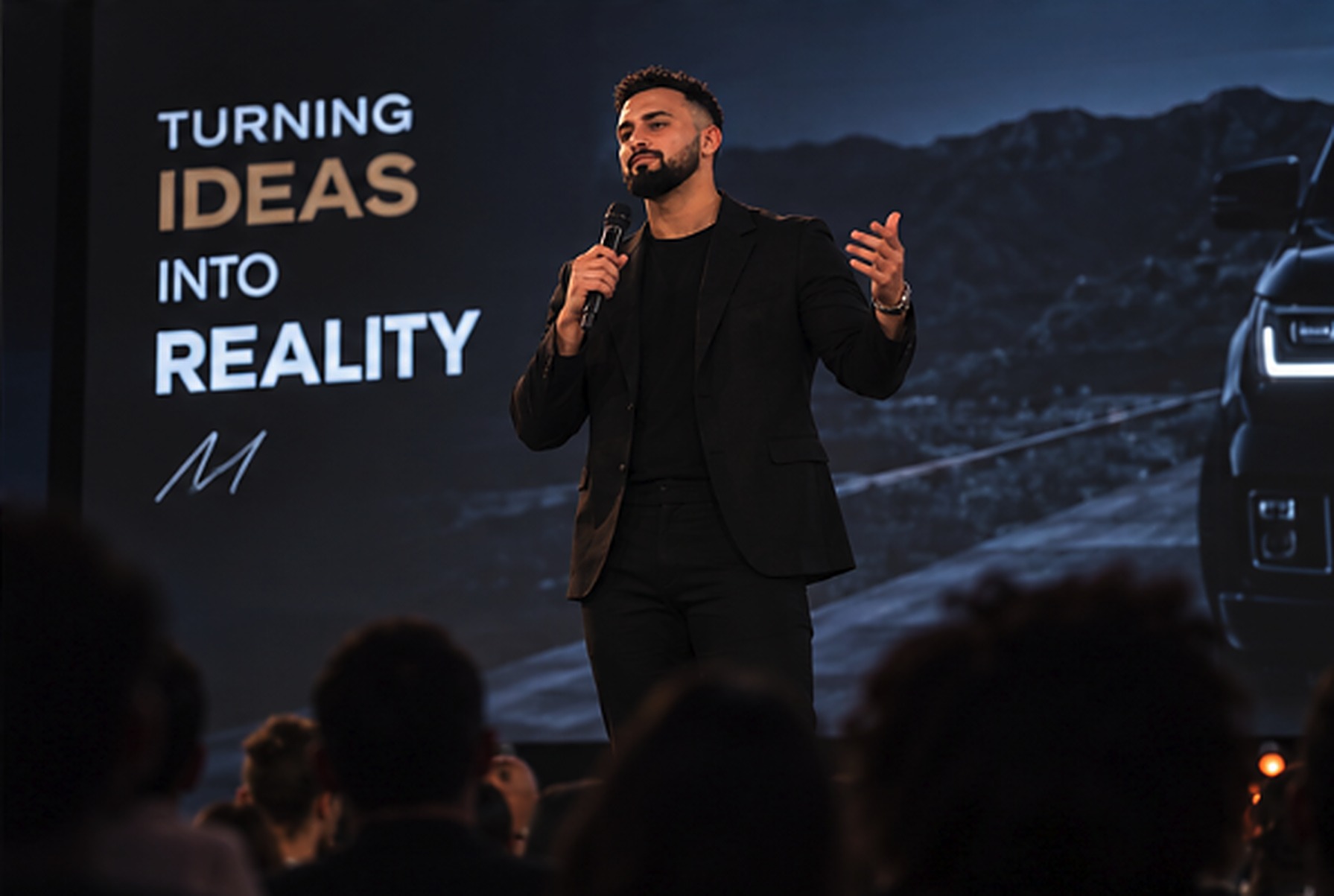 Noah Merriby speaking on stage at a live event